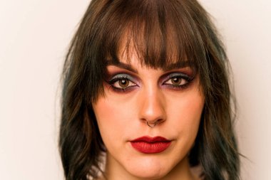 Beyaz arka planda izole edilmiş beyaz makyajlı genç bir kadın.