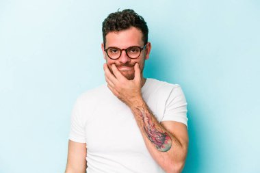 Kafkasyalı genç adam mavi arka planda izole edilmiş iki seçenek arasında şüphe duyuyor.