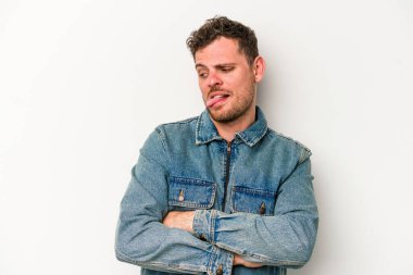 Beyaz arka planda izole edilmiş genç beyaz bir adam. Komik ve dost canlısı bir dil uzatıyor..