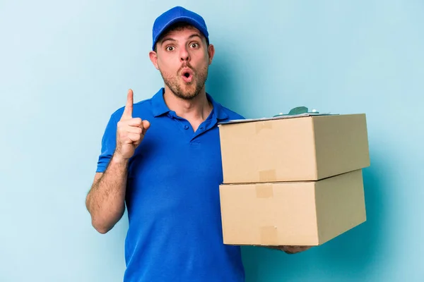 Young Caucasian Delivery Man Isolated Blue Background Having Some Great — Φωτογραφία Αρχείου