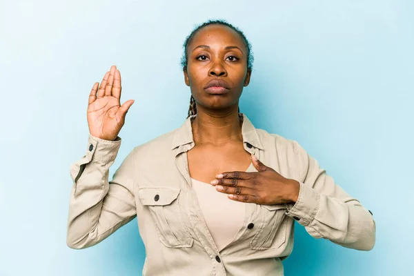 Ung Afrikansk Amerikansk Kvinna Isolerad Blå Bakgrund Sätta Handen Bröstet — Stockfoto