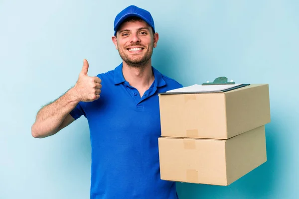 Young Caucasian Delivery Man Isolated Blue Background Smiling Raising Thumb — Stockfoto