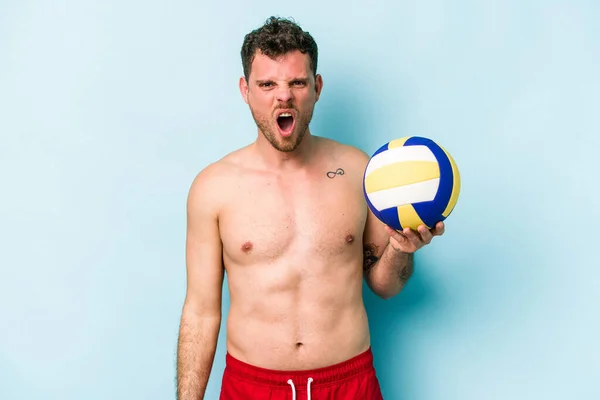 Young Caucasian Man Playing Volley Isolated Blue Background Screaming Very — Stok fotoğraf
