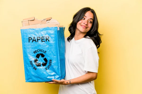 Young Hispanic Woman Recycling Paper Isolated Yellow Background Looks Aside — Stock fotografie