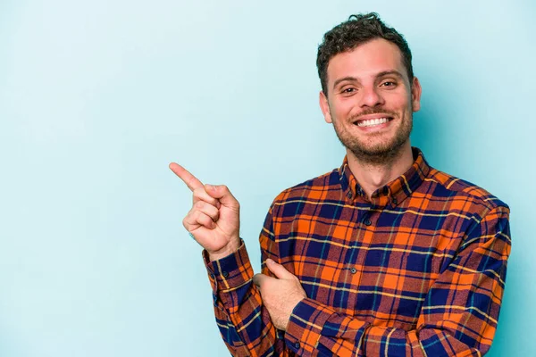 Jovem Caucasiano Isolado Fundo Azul Sorrindo Alegremente Apontando Com Dedo — Fotografia de Stock