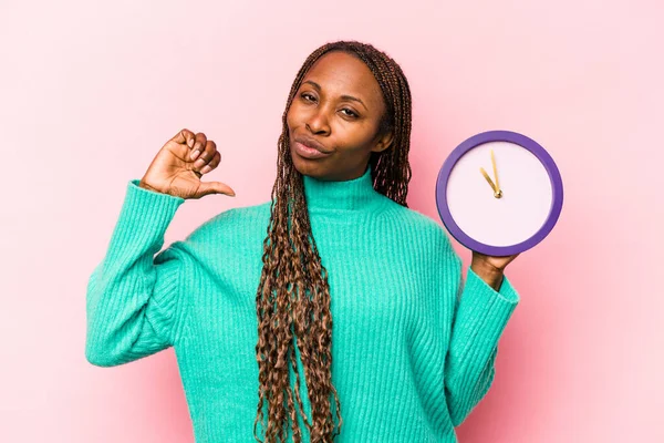 Молодая Афроамериканка Держит Часы Изолированы Розовом Фоне Чувствует Себя Гордой — стоковое фото