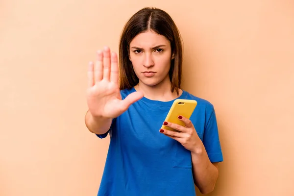 Ung Kaukasiska Kvinna Som Håller Mobiltelefon Isolerad Beige Bakgrund Står — Stockfoto