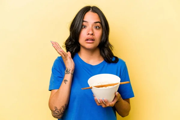 Ung Latinamerikansk Kvinna Äter Ram Isolerad Blå Bakgrund Förvånad Och — Stockfoto