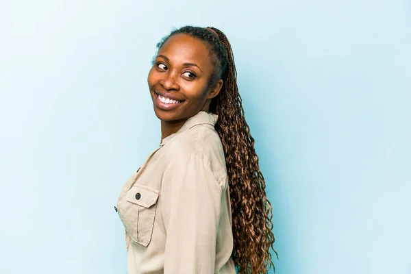 Jonge Afrikaanse Amerikaanse Vrouw Geïsoleerd Blauwe Achtergrond Kijkt Opzij Glimlachend — Stockfoto