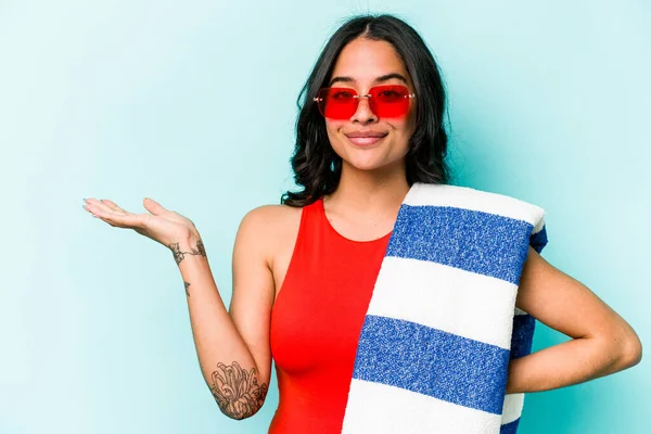 Mavi arka planda plaj havlusu tutan genç İspanyol kadın bir avuç içinin fotokopi çektiğini ve belinde bir el daha tuttuğunu gösteriyor..