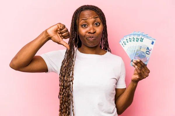 Молодая Афроамериканка Держащая Банкноты Розовом Фоне Показывает Неприязненный Жест Пальцы — стоковое фото