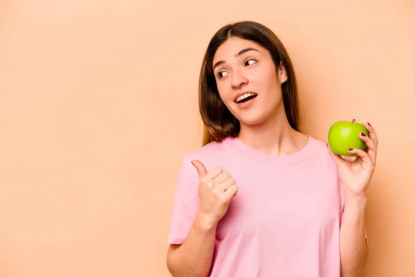 Mujer Hispana Joven Sosteniendo Una Manzana Aislada Puntos Fondo Beige —  Fotos de Stock