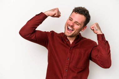 Beyaz arka planda izole edilmiş genç beyaz bir adam zaferden sonra yumruğunu kaldırıyor, kazanan konsept.