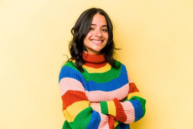 Sarı arka planda izole edilmiş genç İspanyol kadın mutlu, güler yüzlü ve neşeli.