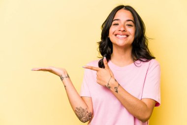 Sarı arka planda izole edilmiş genç İspanyol bir kadın..