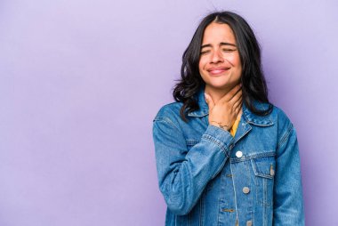 Mor arka planda izole edilmiş genç İspanyol kadın kafasının arkasına dokunuyor, düşünüyor ve bir seçim yapıyor..