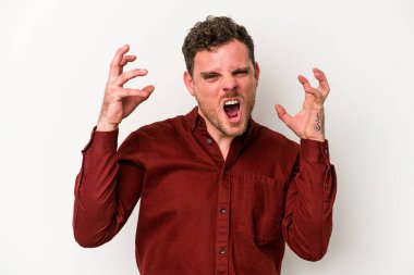 Beyaz arka planda izole edilmiş genç beyaz bir adam öfkeyle bağırıyor..