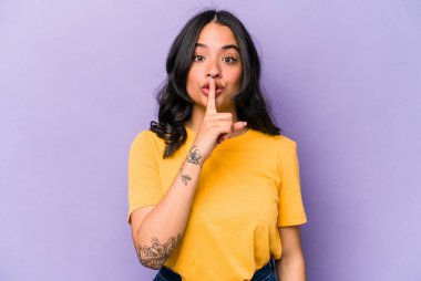 Mor arka planda izole edilmiş genç İspanyol kadın ya sır saklıyor ya da sessizlik istiyor..