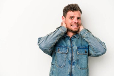 Beyaz arka planda izole edilmiş genç beyaz bir adam kafasının arkasına dokunuyor, düşünüyor ve bir seçim yapıyor..