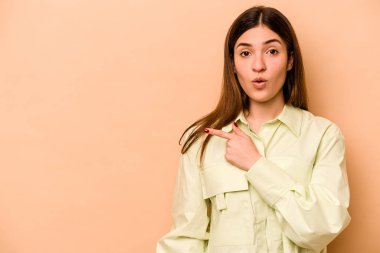 Latin kökenli genç bir kadın bej arka planda izole edilmiş.