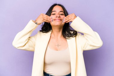 Mor arka planda izole edilmiş genç İspanyol kadın iki seçenek arasında şüphe duyuyor.