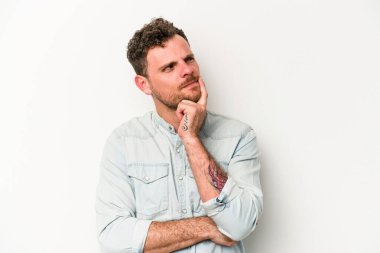 Beyaz arka planda izole edilmiş genç beyaz bir adam bir strateji planlıyor, bir iş yolu düşünüyor..