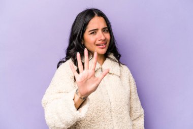 Mor arka planda izole edilmiş genç İspanyol kadın yakın bir tehlike nedeniyle şoka uğruyor.