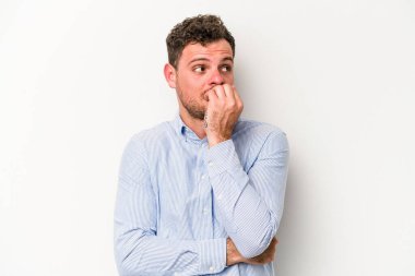 Beyaz arka planda izole edilmiş, tırnak yiyen, gergin ve endişeli genç bir beyaz adam..