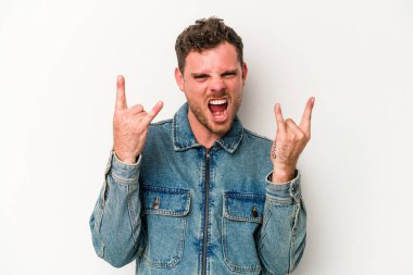 Beyaz arka planda izole edilmiş genç beyaz bir adam boynuzlarını devrim konsepti olarak gösteriyor..