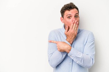 Beyaz arka planda izole edilmiş genç beyaz adam yan tarafı işaret ediyor