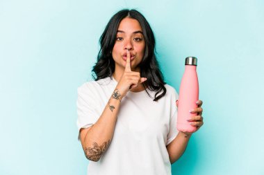 Mavi arka planda termosu olan genç İspanyol kadın bir sır saklıyor ya da sessizlik istiyor..