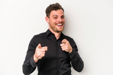 Beyaz arka planda izole edilmiş genç beyaz adam parmaklarıyla ön tarafı işaret ediyor..