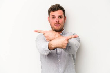 Beyaz arka plan noktalarında izole genç beyaz adam, iki seçenek arasında seçim yapmaya çalışıyor.