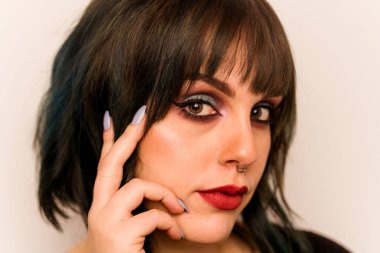 Beyaz arka planda izole edilmiş beyaz makyajlı genç bir kadın.