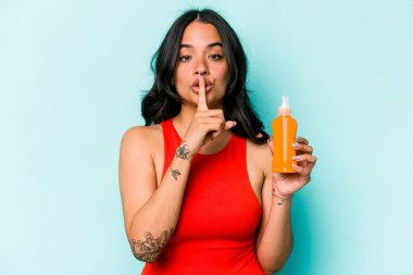 Mavi arka planda güneş kremi tutan genç İspanyol kadın bir sır saklıyor ya da sessizlik istiyor..