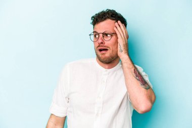 Mavi arka planda izole genç beyaz adam şok oldu, o önemli bir toplantı hatırladı.