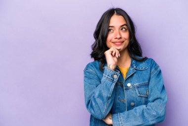 Mor arka planda izole edilmiş genç İspanyol kadın rahatlamış bir şeyin fotokopi odasına baktığını düşünüyor..