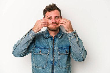 Beyaz arka planda izole genç beyaz adam iki seçenek arasında şüphe.