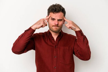 Beyaz arka planda izole edilmiş genç beyaz bir adam bir göreve odaklanmış, işaret parmaklarını işaret ediyor..