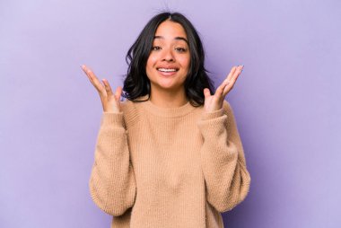 Mor arka planda izole edilmiş genç İspanyol kadın kahkahalarla gülüyor..