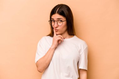 Latin kökenli genç bir kadın bej arka planda izole edilmiş. Bir strateji planlıyor, bir iş yolu düşünüyor..