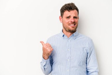 Beyaz arka planda izole edilmiş genç beyaz bir adam işaret parmağıyla fotokopi alanını işaret ederek şok oldu..