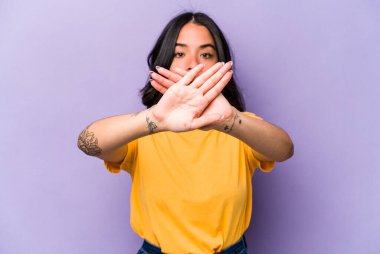 Mor arka planda izole edilmiş genç İspanyol kadın inkar jesti yapıyor.