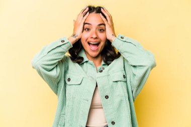 Genç İspanyol kadın sarı arka planda izole edilmiş bağırıyor, çok heyecanlı, tutkulu, bir şeyden memnun..