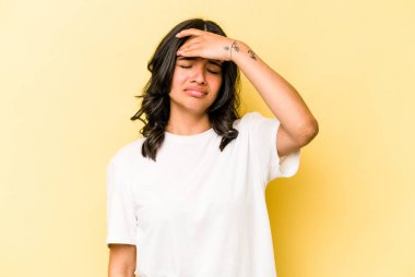 Sarı arka planda izole edilmiş genç İspanyol kadın şakaklara dokunuyor ve baş ağrısı çekiyor..