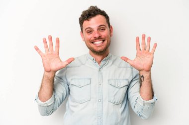 Beyaz arka planda izole edilmiş beyaz tenli genç adam on numarayı elleriyle gösteriyor..