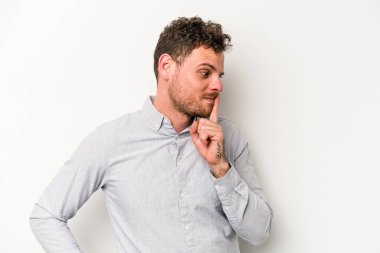 Beyaz arka planda izole edilmiş genç beyaz bir adam ya sır saklıyor ya da sessizlik istiyor..