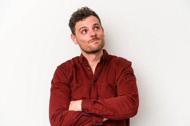 Beyaz arka planda izole edilmiş genç beyaz adam hedeflere ve amaçlara ulaşmayı hayal ediyor.