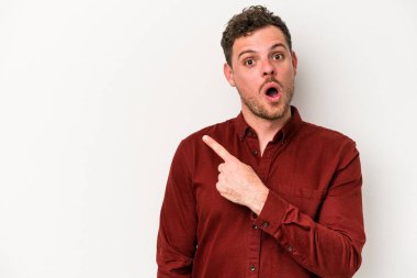 Beyaz arka planda izole edilmiş genç beyaz adam yan tarafı işaret ediyor