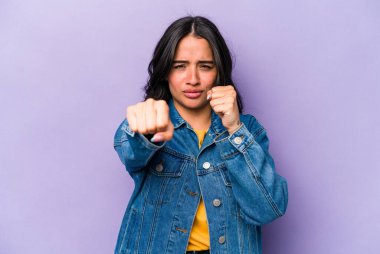 Mor arka planda izole edilmiş genç İspanyol kadın bir tartışma yüzünden yumruk, öfke, kavga ve boks atıyor..